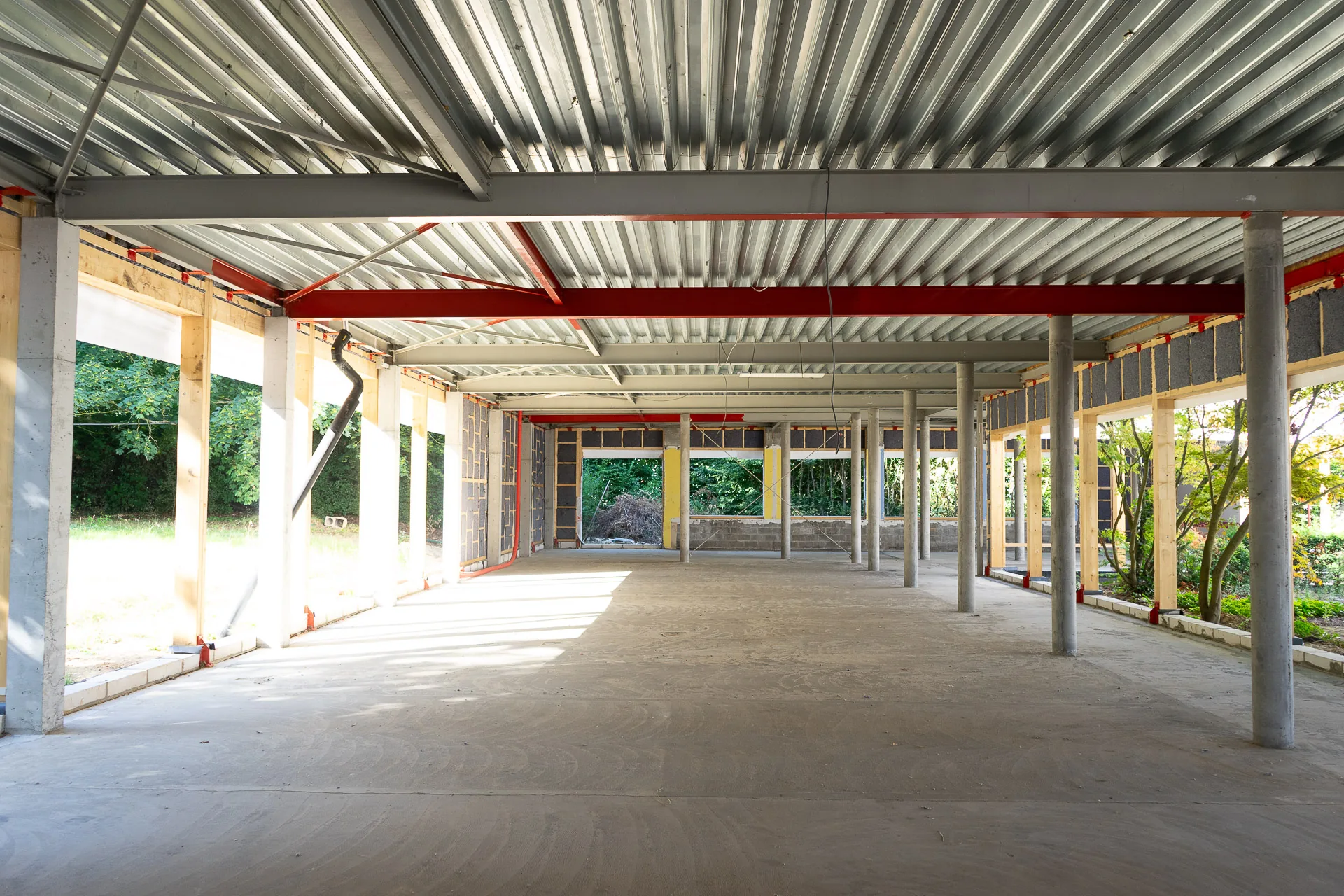 Le plateau rénové du campus Odoo : la nouvelle structure d'acier, poutres rouges et colonnes, sous un bac acier
