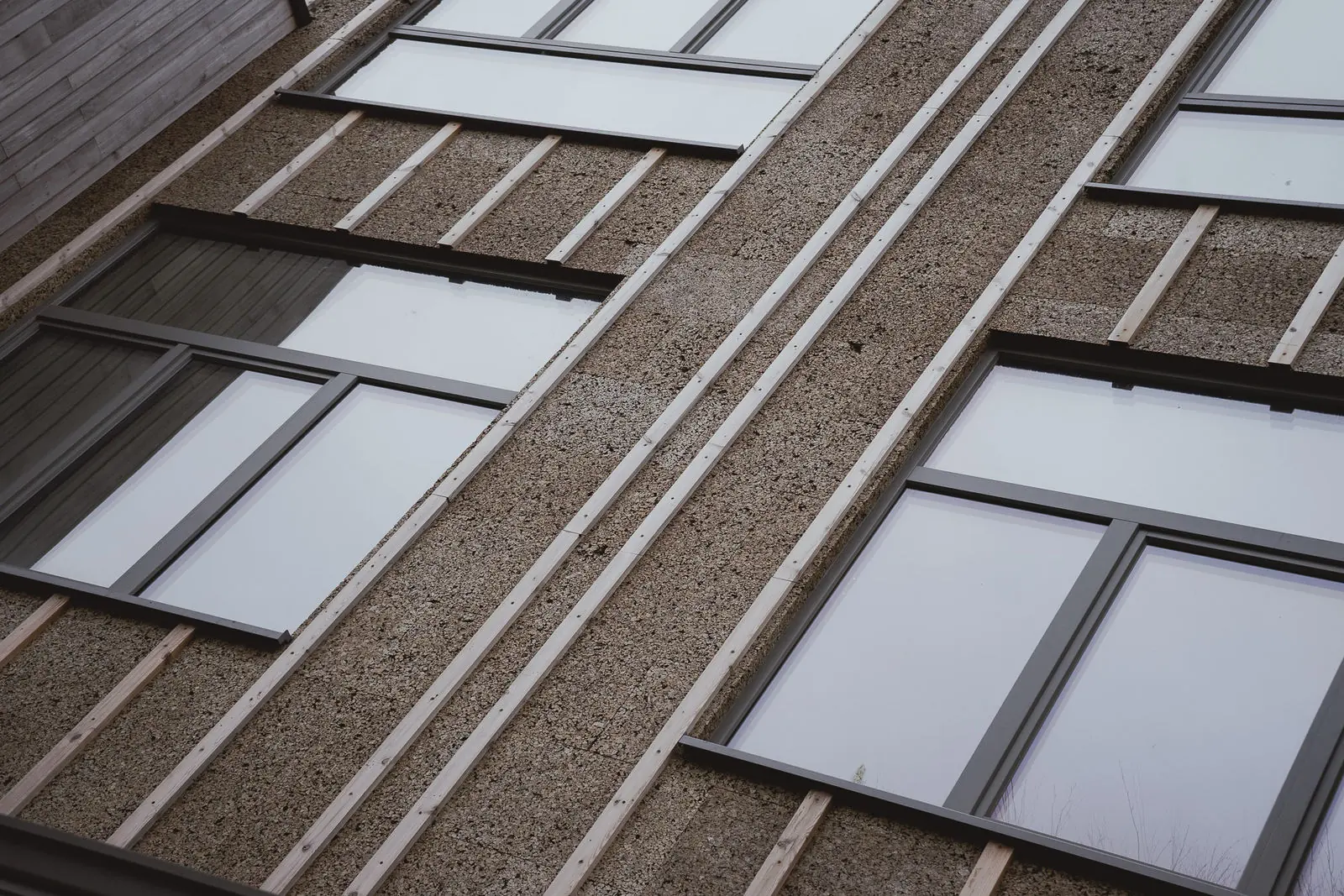 Détail rasant de la façade : panneaux de liège expansé, tasseaux de bois et châssis, sans couche intermédiaire