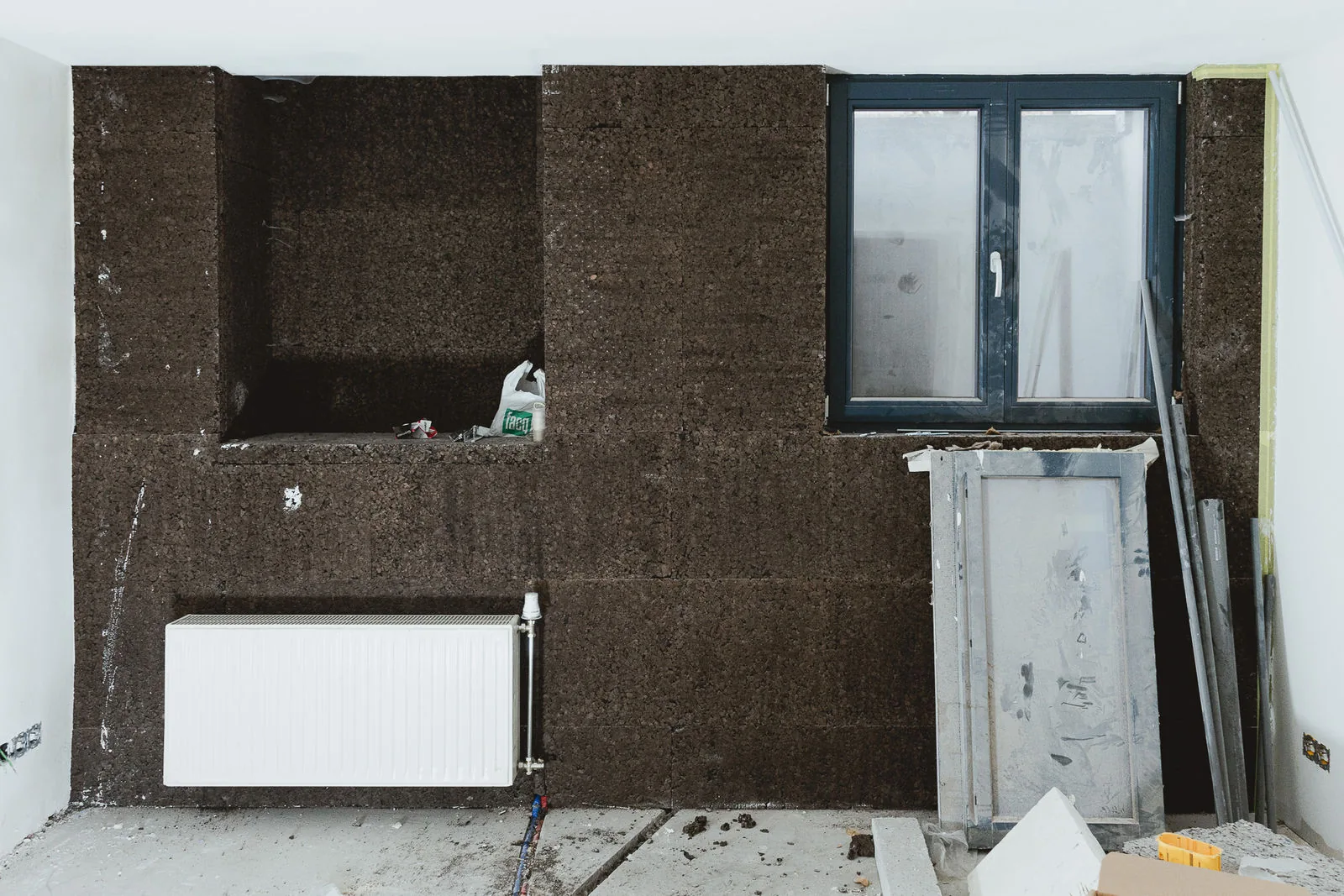 Mur intérieur doublé de panneaux isolants, avec un radiateur existant remis en service