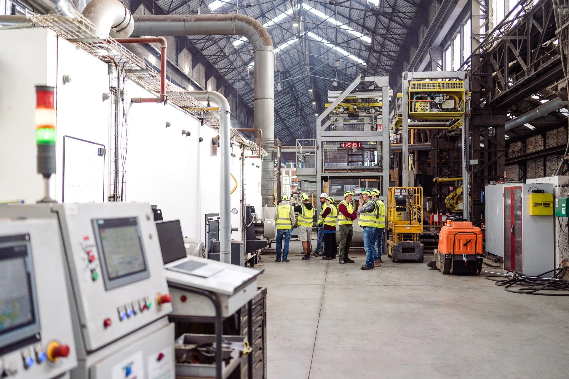 Les participants de la journée Embuild devant la ligne de production de Gramitherm, sous la verrière de l'usine d'Auvelais