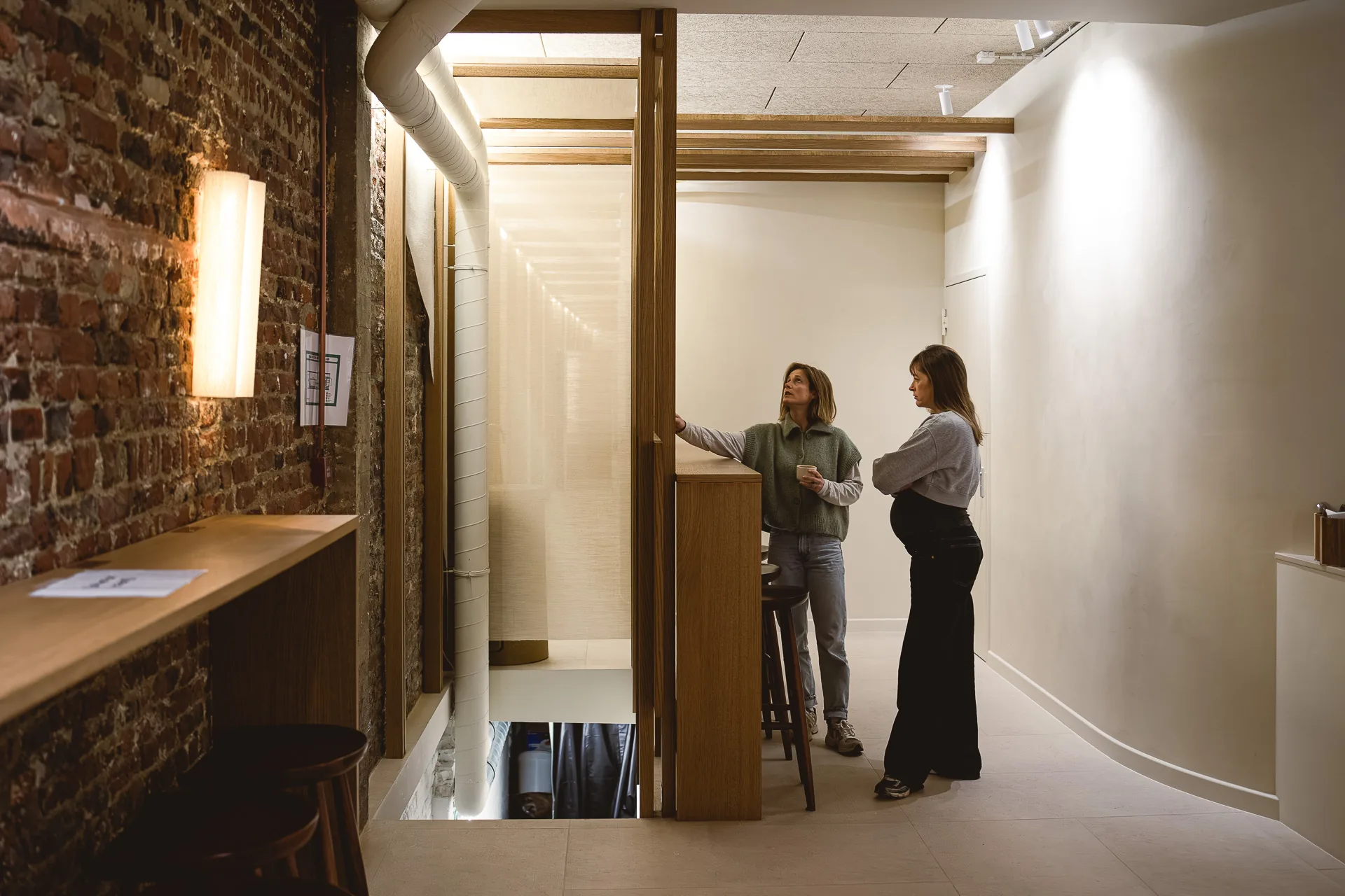 Le couloir du studio, deux personnes en conversation devant la réception