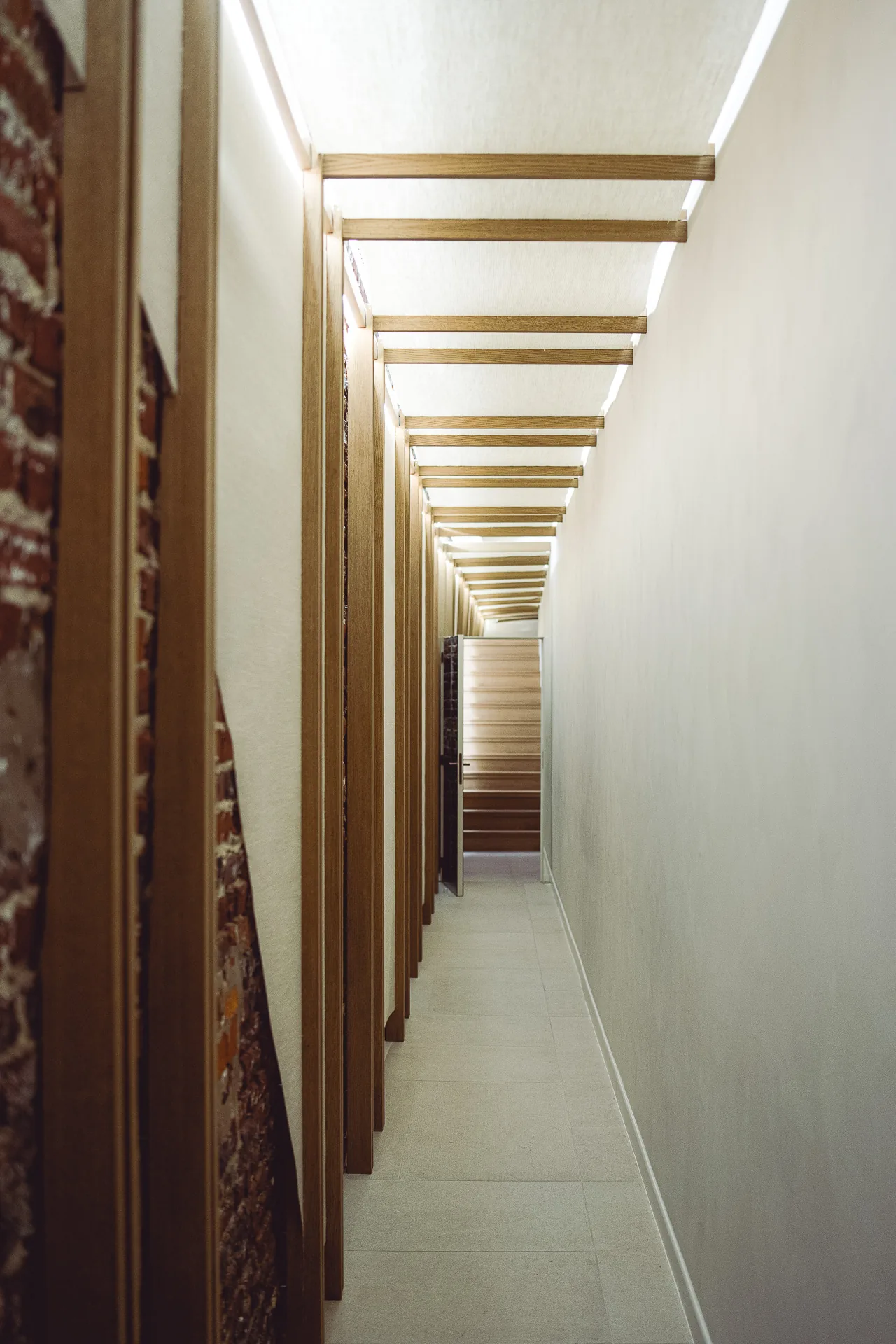 Le couloir du studio, enfilade de tasseaux de bois et panneaux de lin