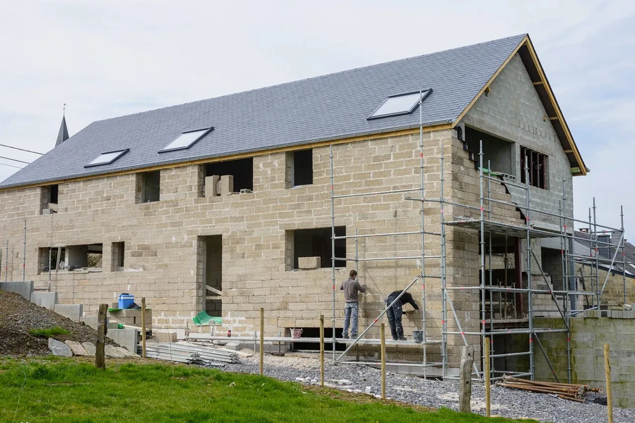Maison en construction montée en blocs de chanvre, échafaudage et toiture en cours