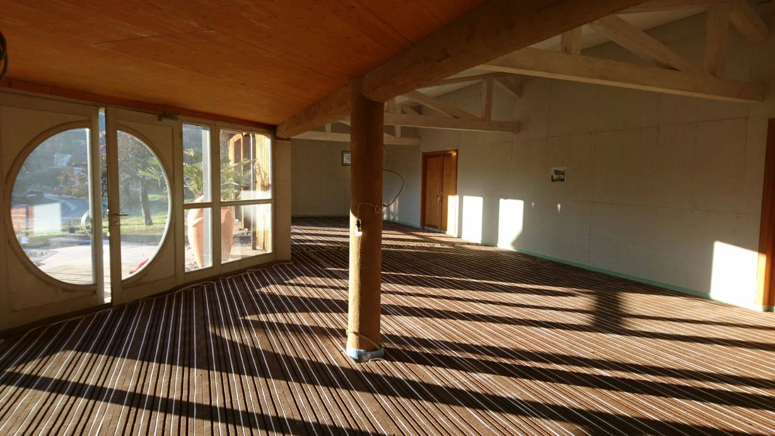 Plateau terminé sur chape sèche Lithotherm, charpente bois et baie ronde