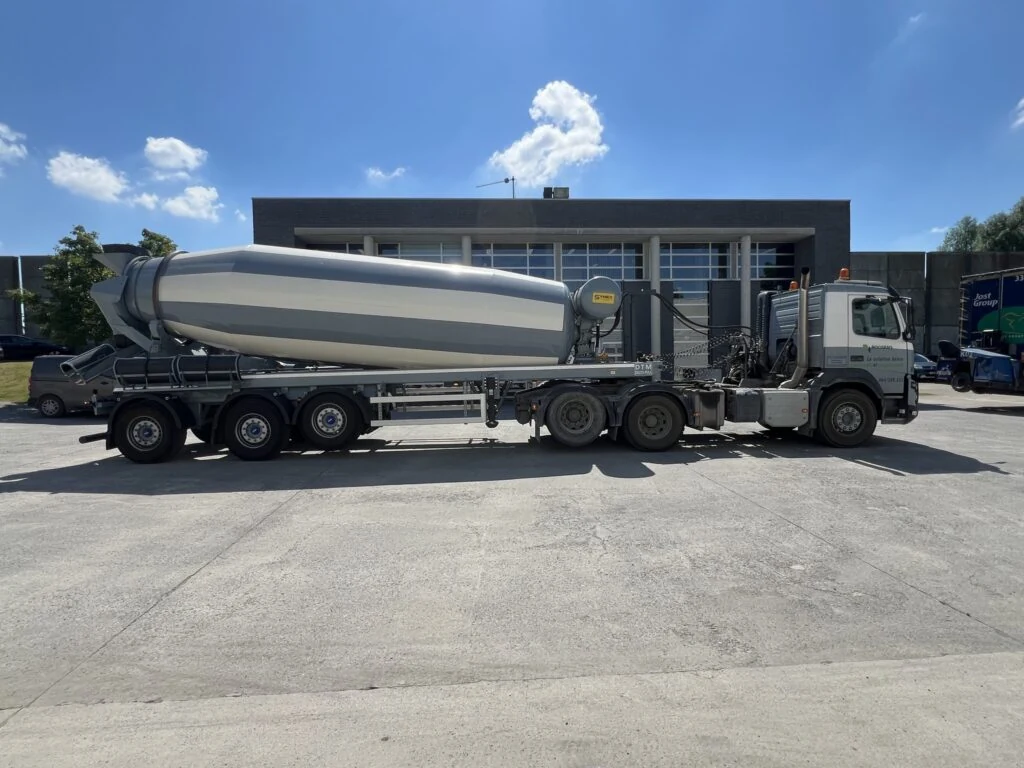 Camion-malaxeur Roosens Béton stationné devant les halls de production