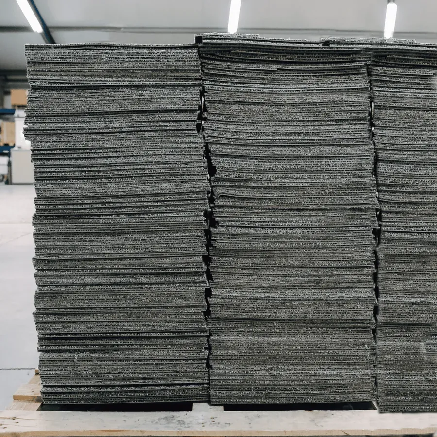 Stacks of lifted office carpet tiles on a pallet