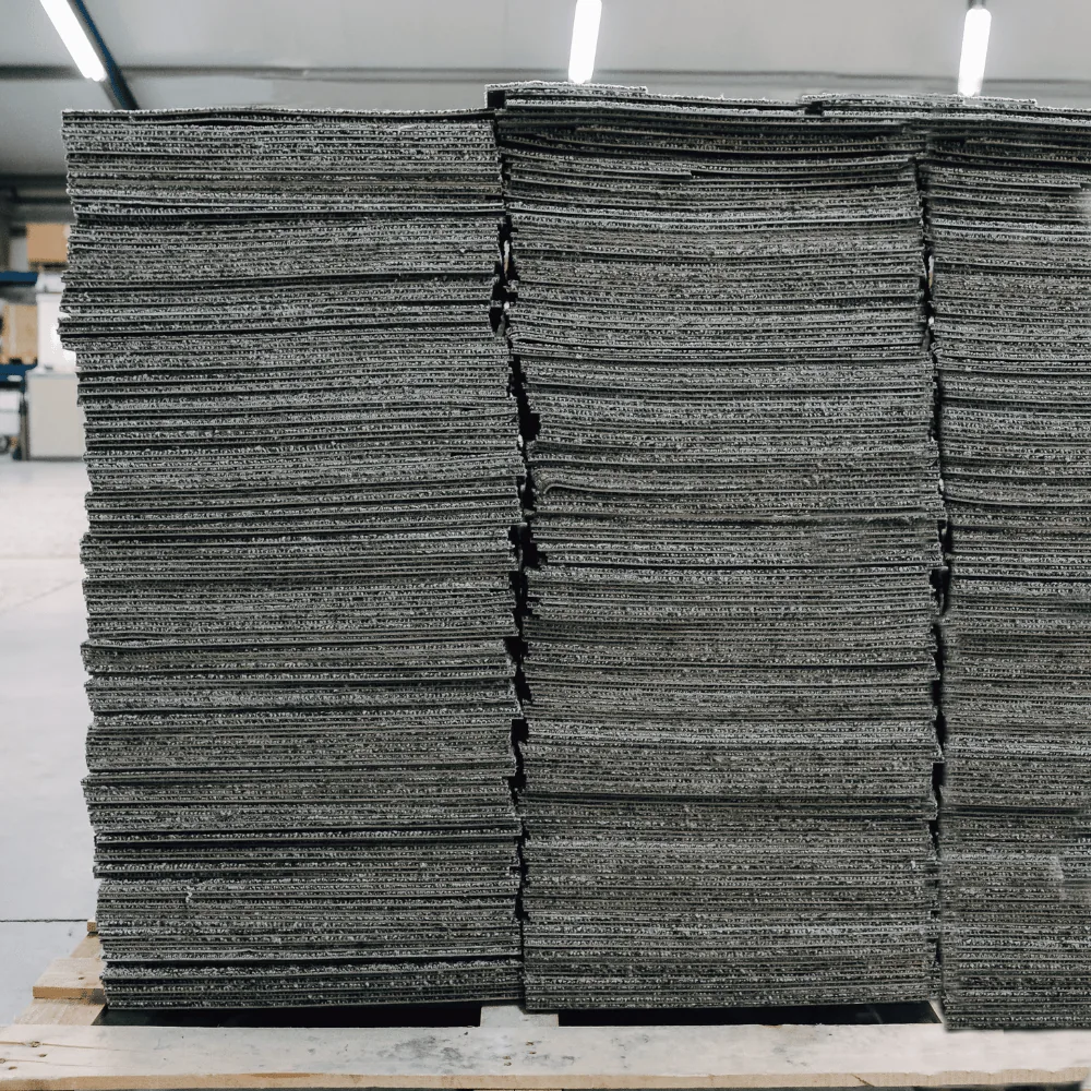 Stacks of lifted office carpet tiles on a pallet
