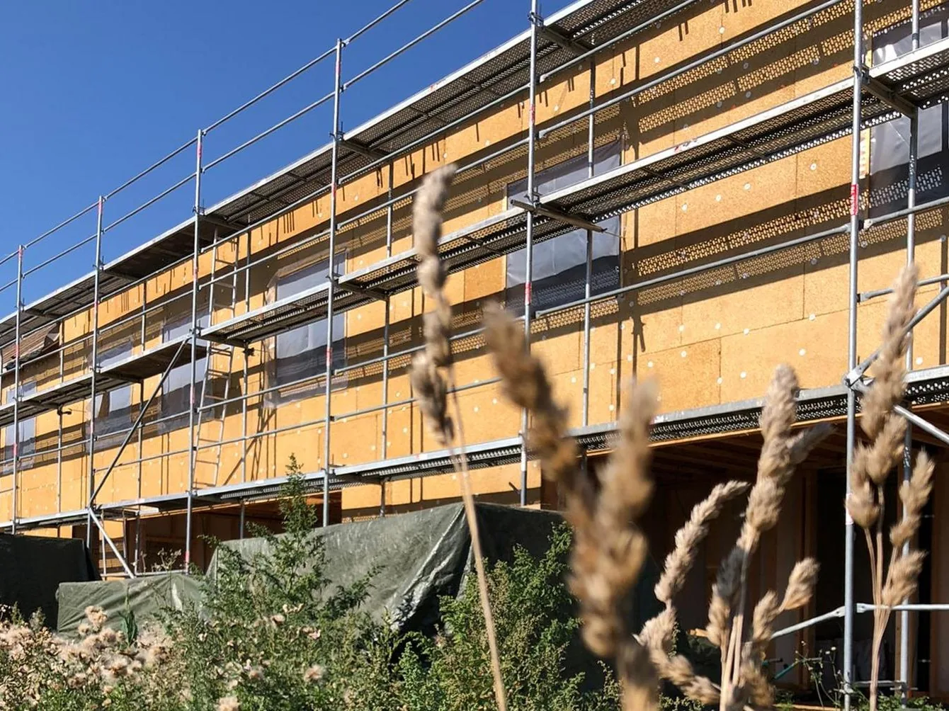 Façade isolée en panneaux de paille en cours de chantier, échafaudage monté