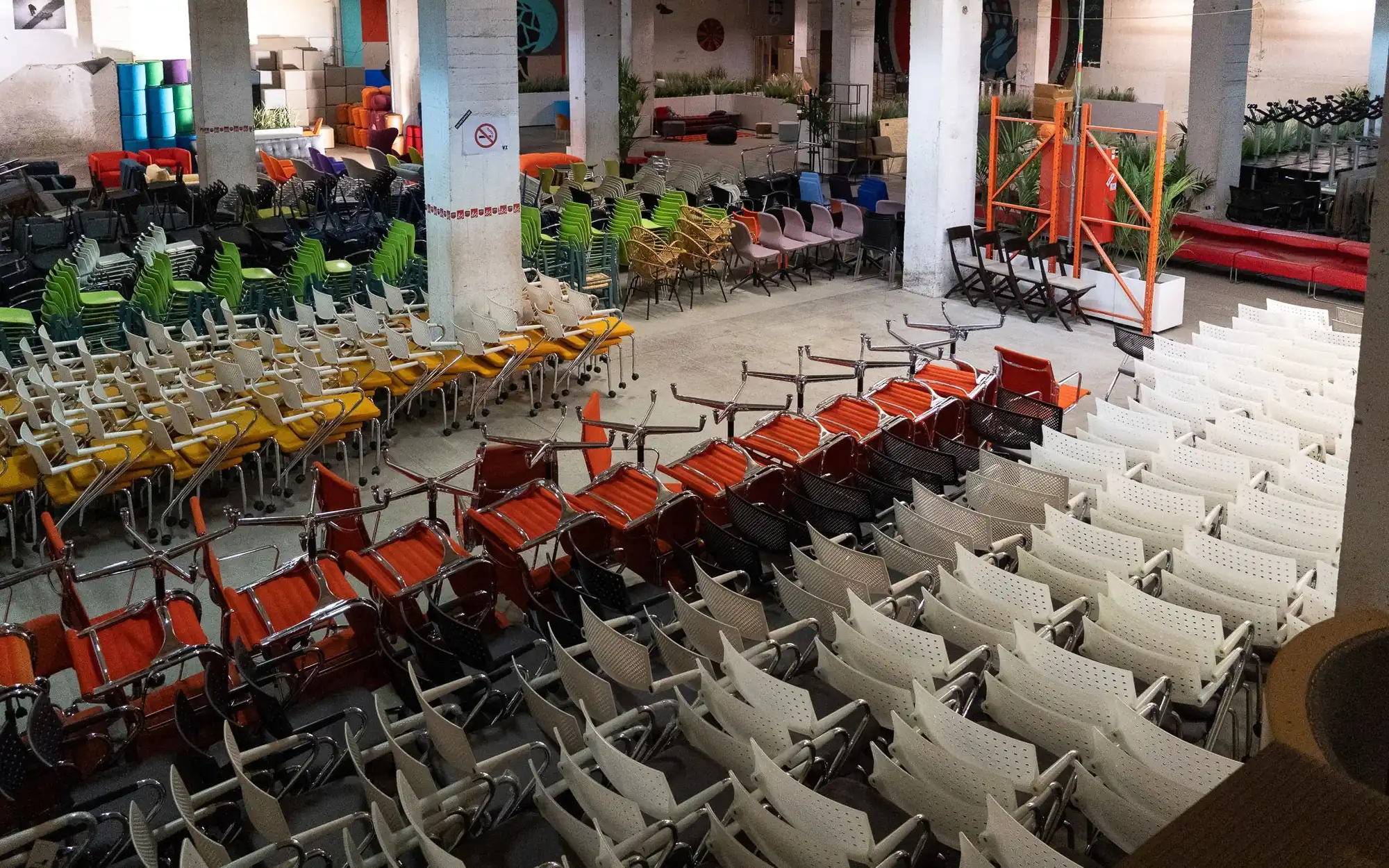 Rows of second-hand chairs and office chairs in a warehouse