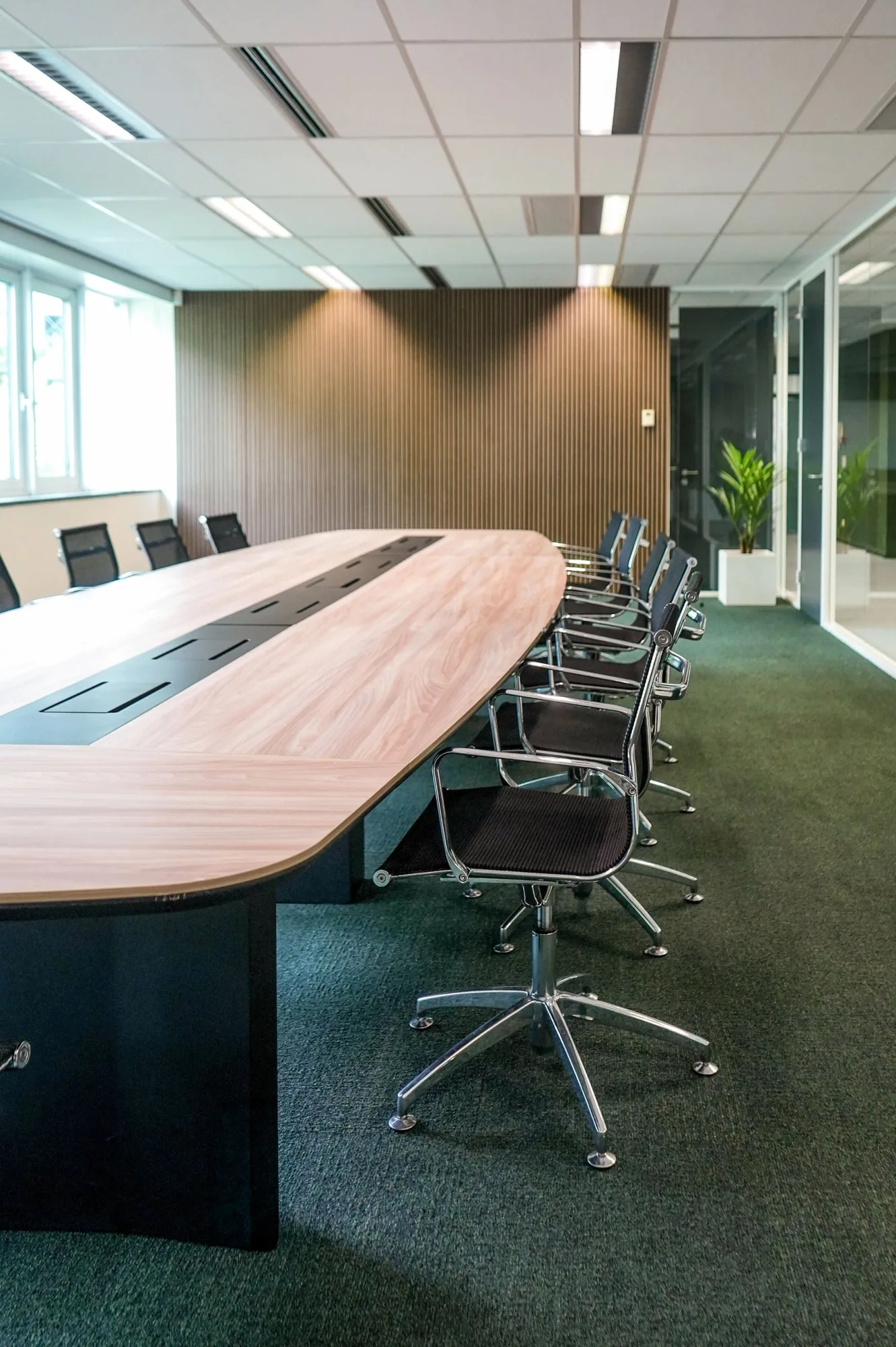 Meeting room furnished with a large table and reused office chairs