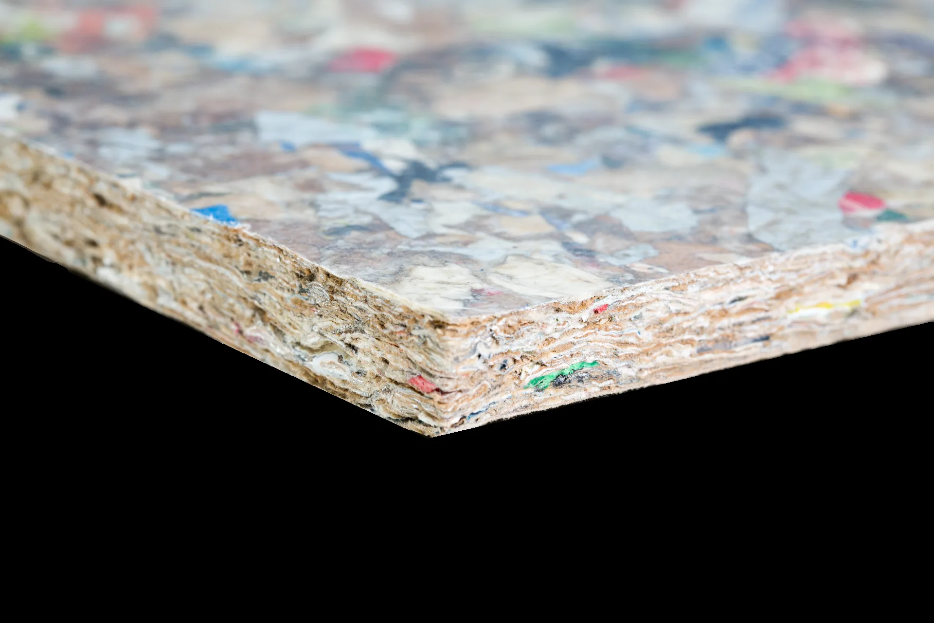 Panneau PackWall Design de Recoma, prise de vue studio sur fond neutre : le moucheté polychrome caractéristique (éclats de plastique et d'aluminium des briques alimentaires) et la tranche feuilletée sont nets et lisibles dès la vignette. © Recoma AB